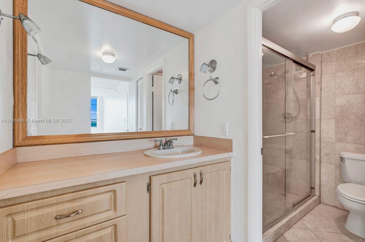 2025 Northeast 164th Street, Unit 716 North Miami Beach, FL 33162 - Photo 29 of 39 a bathroom with a sink a toilet and shower