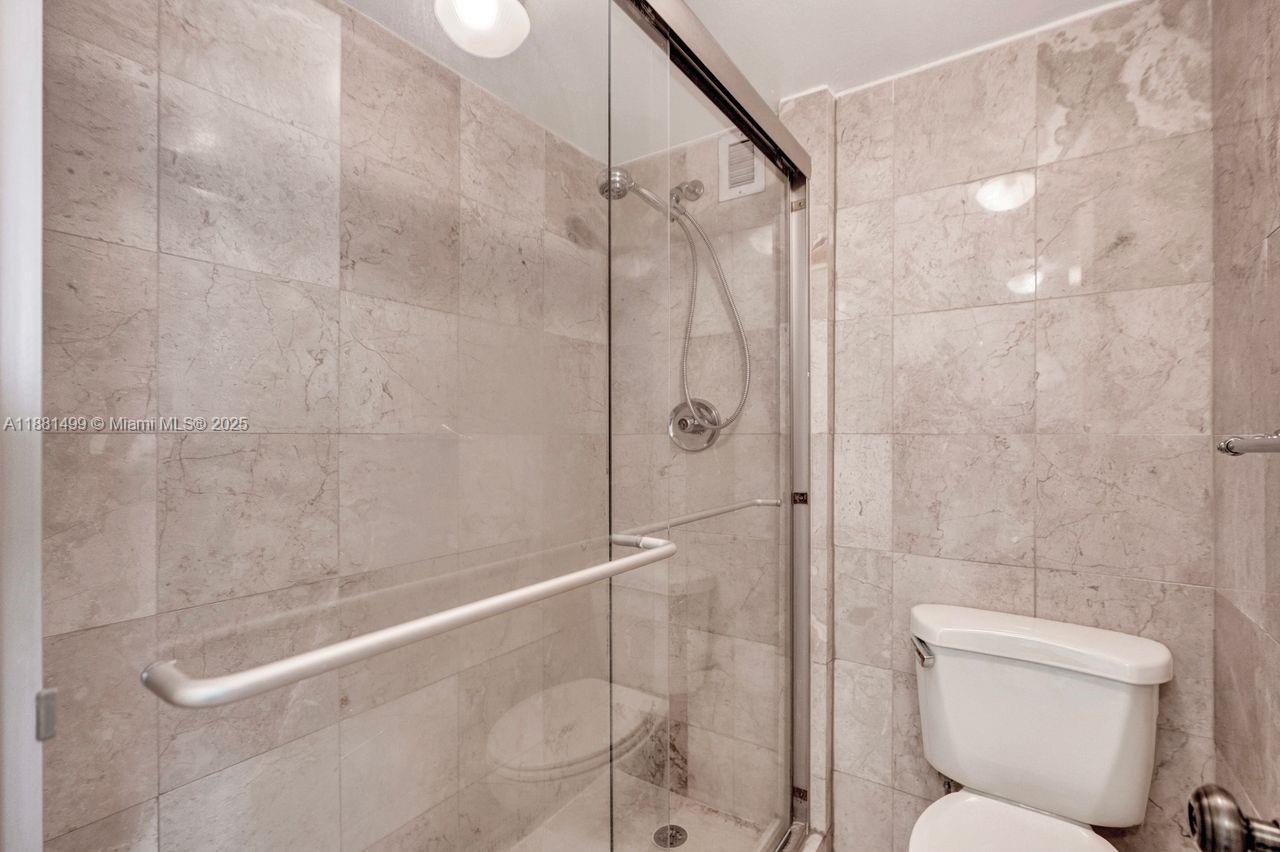2025 Northeast 164th Street, Unit 716 North Miami Beach, FL 33162 - Photo 30 of 39 a bathroom with a toilet and shower