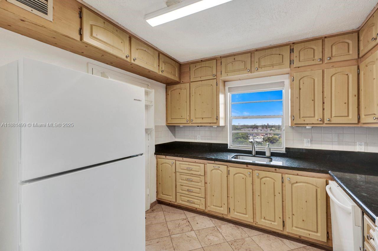 2025 Northeast 164th Street, Unit 716 North Miami Beach, FL 33162 - Photo 3 of 39 a kitchen with stainless steel appliances granite countertop a stove a refrigerator a sink and dishwasher