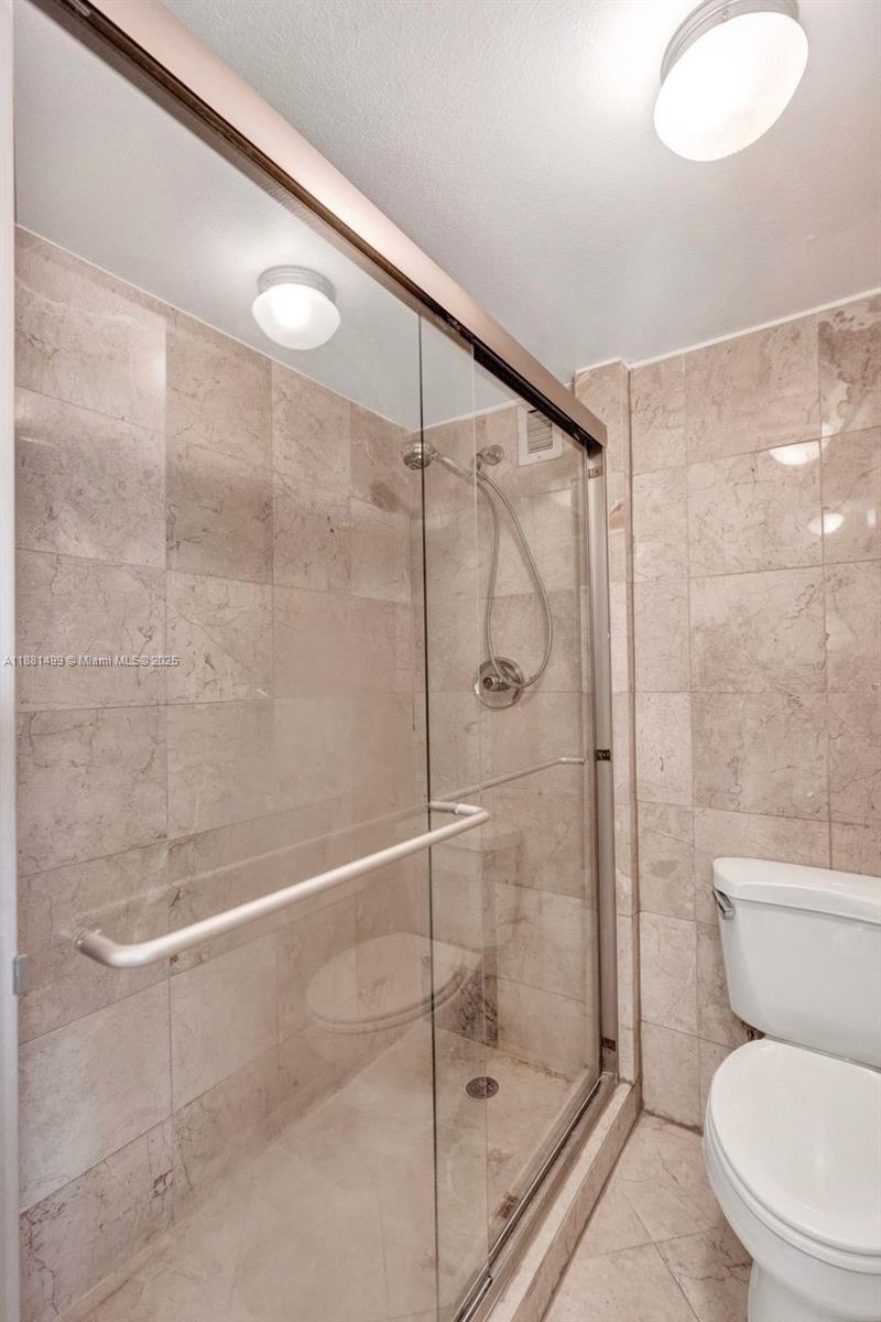 2025 Northeast 164th Street, Unit 716 North Miami Beach, FL 33162 - Photo 31 of 39 a bathroom with a shower and a toilet