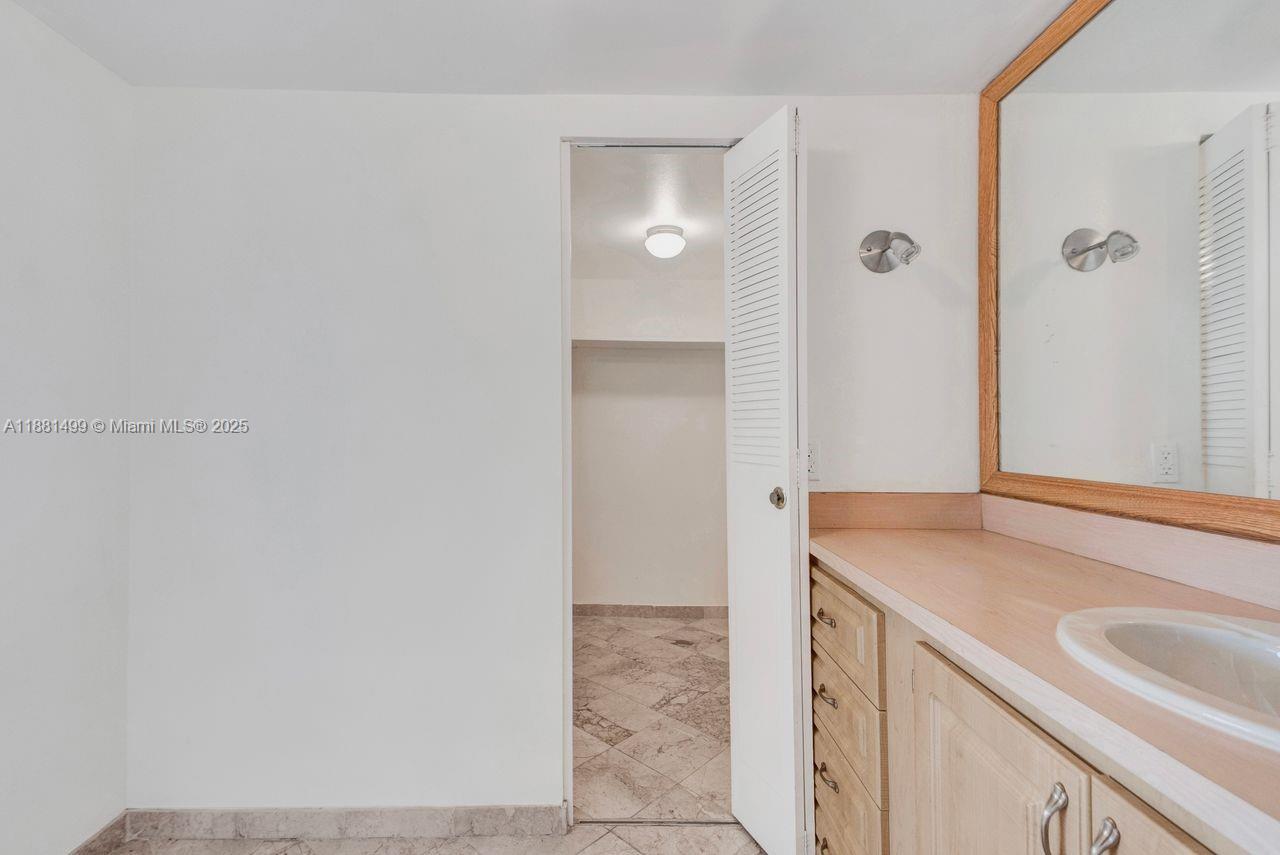 2025 Northeast 164th Street, Unit 716 North Miami Beach, FL 33162 - Photo 32 of 39 a bathroom with a sink and a mirror