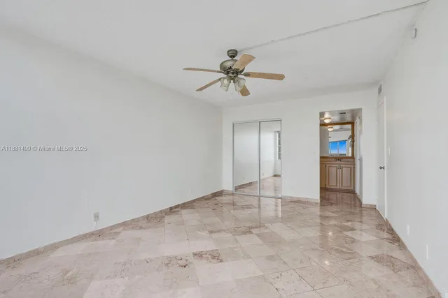 a view of an empty room with a ceiling fan
