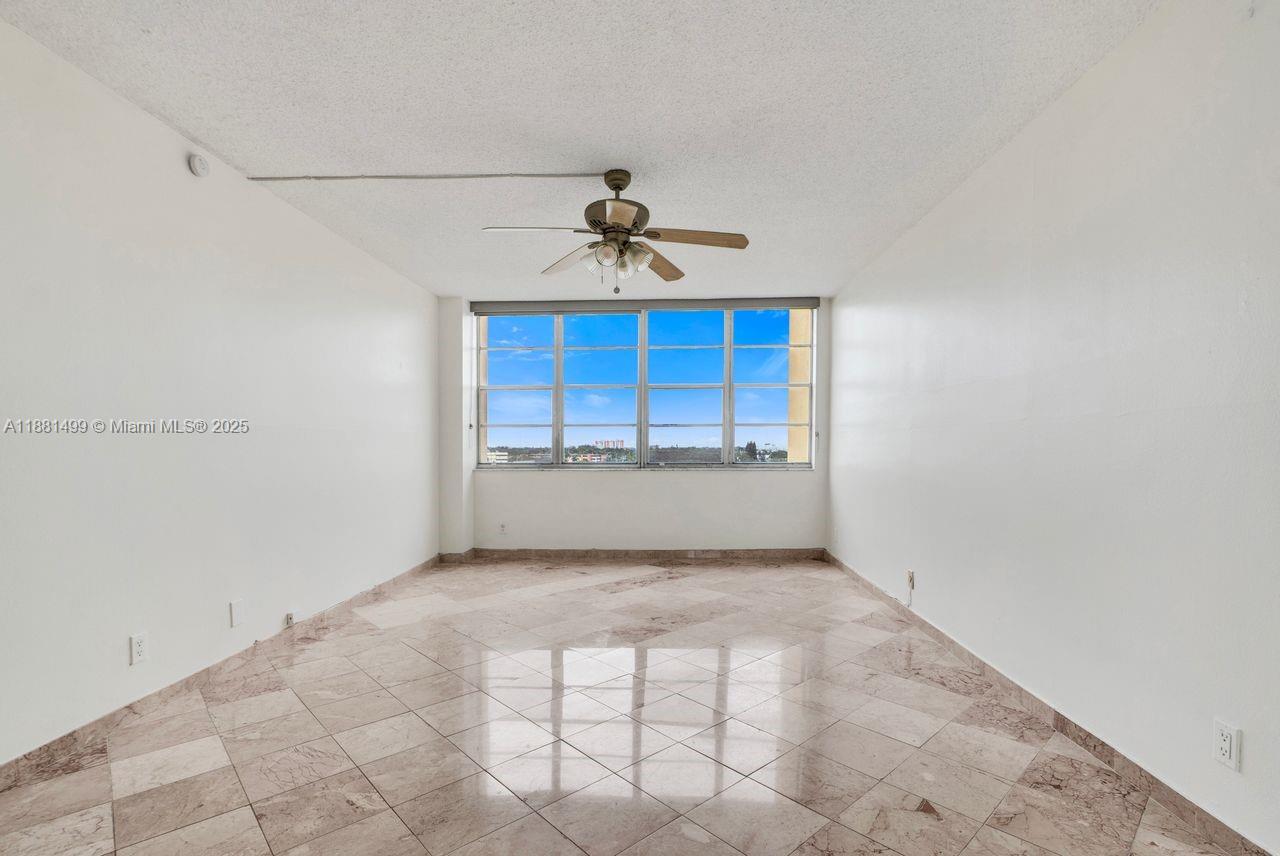 2025 Northeast 164th Street, Unit 716 North Miami Beach, FL 33162 - Photo 38 of 39 a view of a room with a ceiling fan and carpet