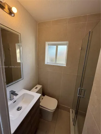 a bathroom with a sink a toilet and mirror