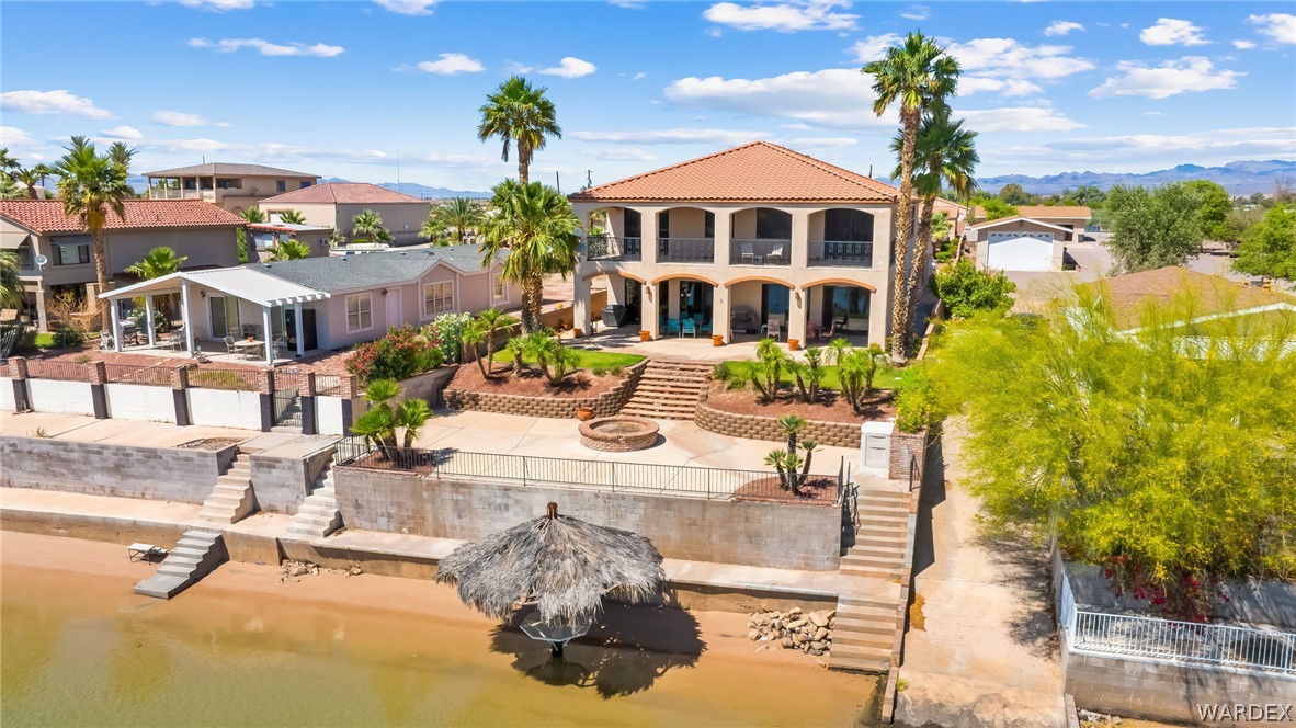 1084 Dike Road Mohave Valley, AZ 86440 - Photo 12 of 75 Waterfront property featuring a tiered terraced hardscape, a ground-level patio with a fire pit, and direct water access via concrete steps