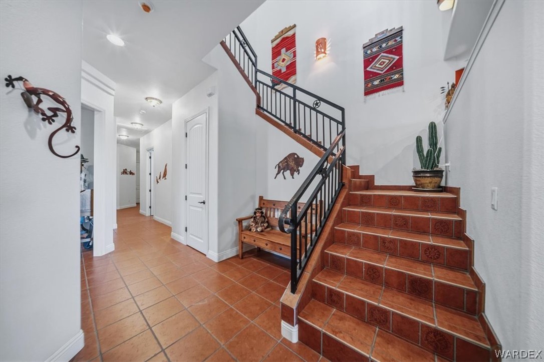 1084 Dike Road Mohave Valley, AZ 86440 - Photo 23 of 75 Two-story entry featuring terracotta tile flooring, a wrought iron staircase with wood handrails, and recessed lighting
