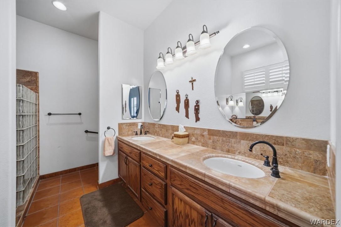 1084 Dike Road Mohave Valley, AZ 86440 - Photo 27 of 75 a bathroom with a granite countertop sink a mirror and shower