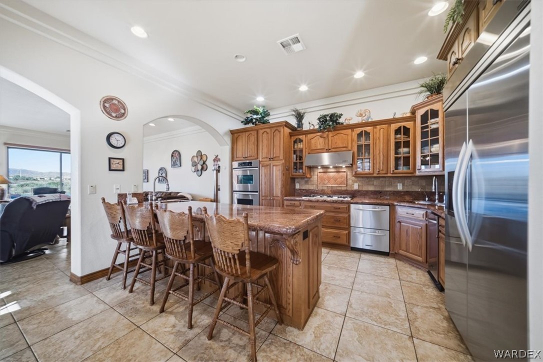 1084 Dike Road Mohave Valley, AZ 86440 - Photo 43 of 75 a kitchen with stainless steel appliances kitchen island granite countertop a table and chairs