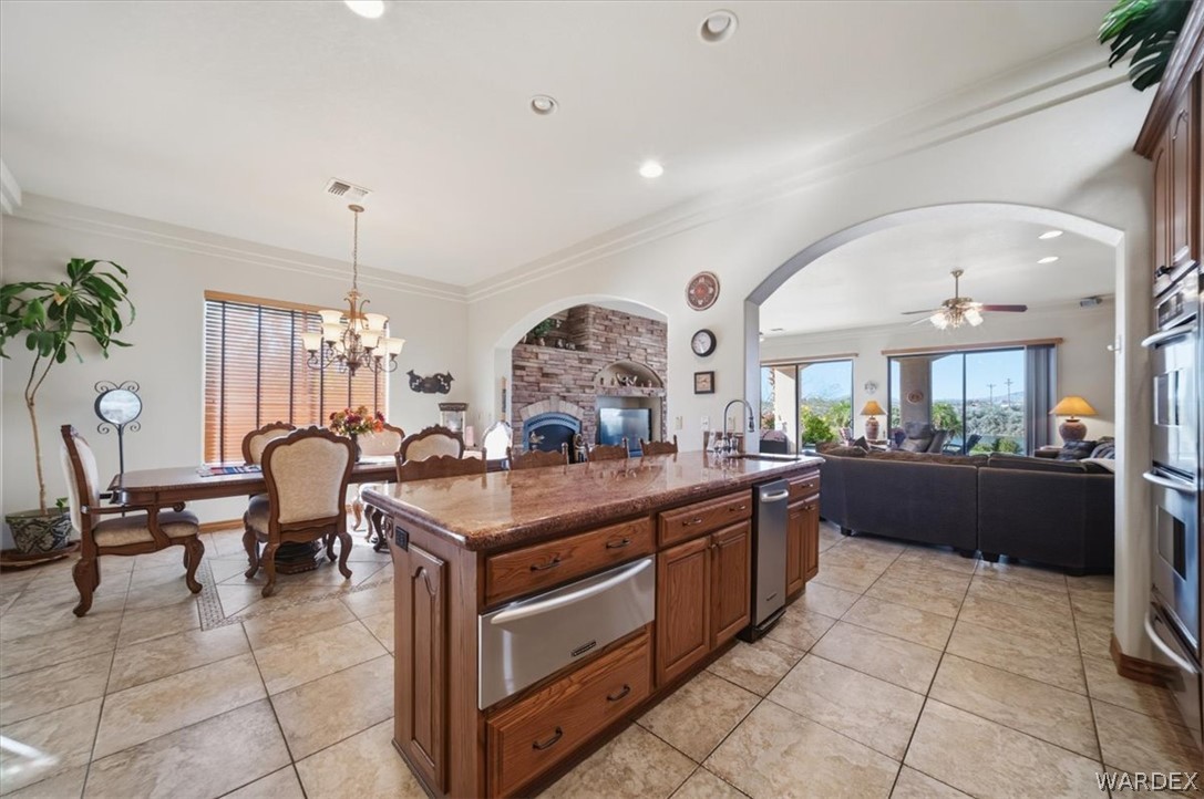 1084 Dike Road Mohave Valley, AZ 86440 - Photo 46 of 75 Gourmet kitchen island with granite countertop, integrated stainless steel dishwasher, and rich wood cabinetry