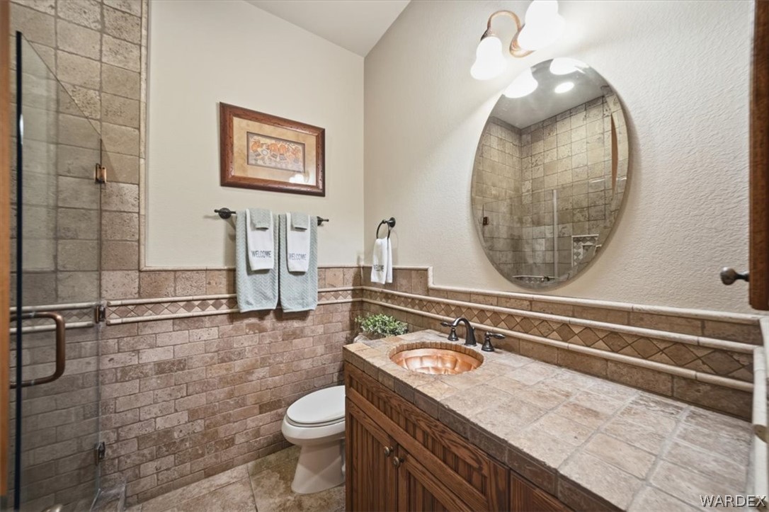 1084 Dike Road Mohave Valley, AZ 86440 - Photo 51 of 75 Bathroom featuring a copper vessel sink, tile countertop, and wood-finish vanity