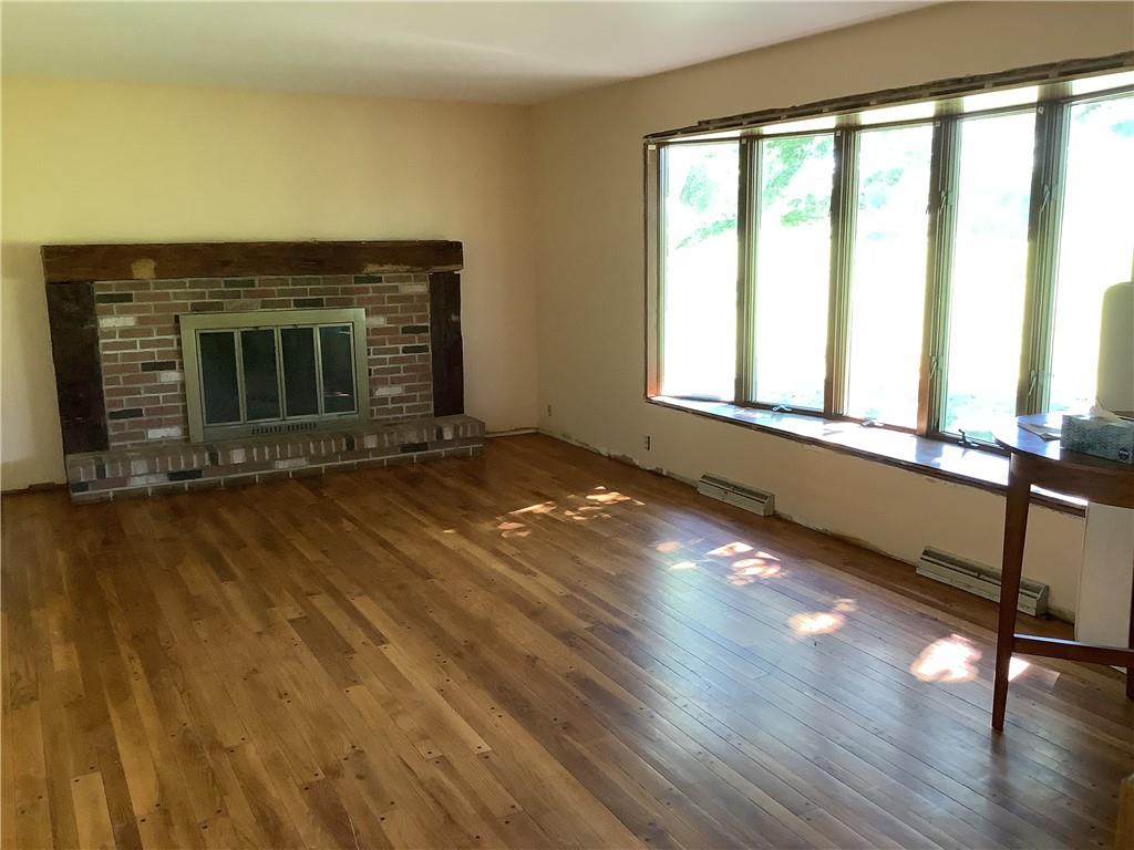 557 Hopper Road Transfer, PA 16154 - Photo 3 of 18 a view of an empty room with exposed radiator and a fireplace