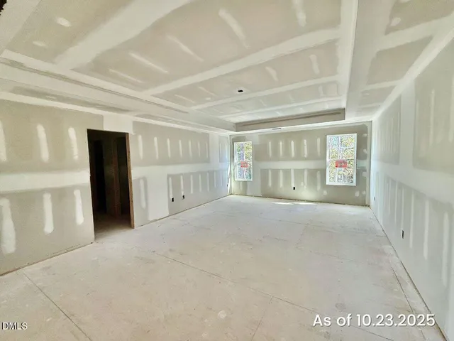 a view of an empty room with closet and a window