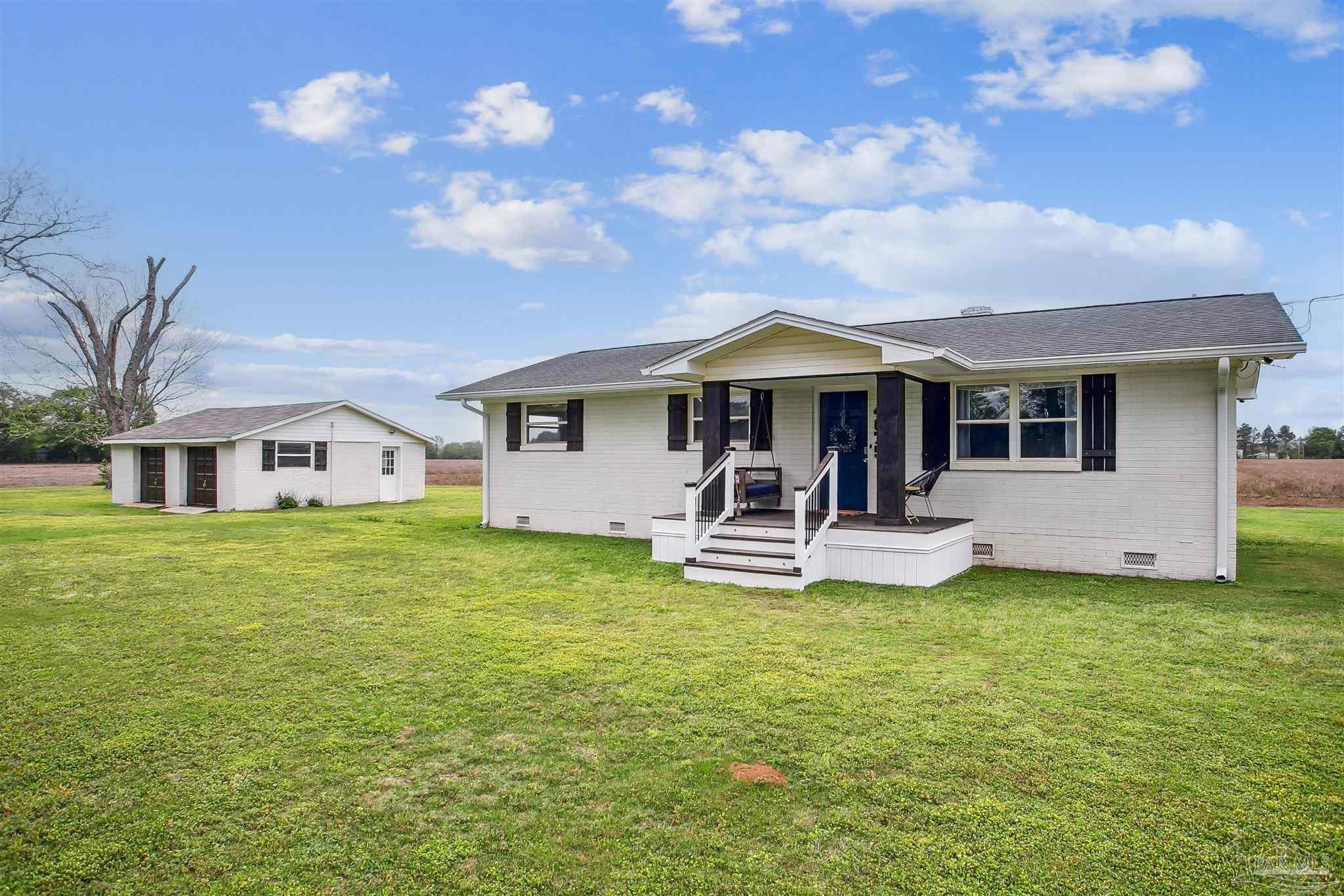 a view of a house with a yard patio and swimming pool