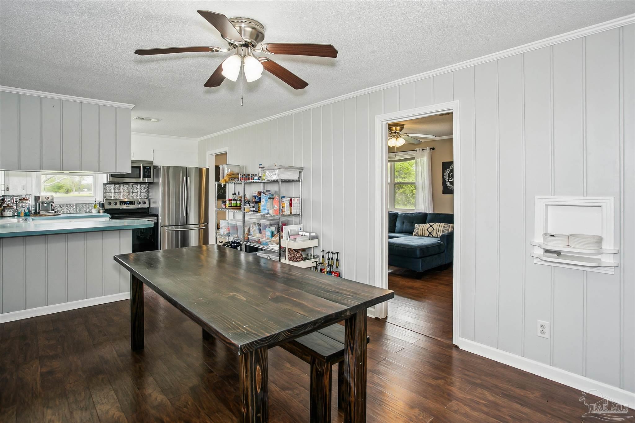 4075 Macks Road Century, FL 32535 - Photo 11 of 35 a kitchen with a table chairs refrigerator and cabinets