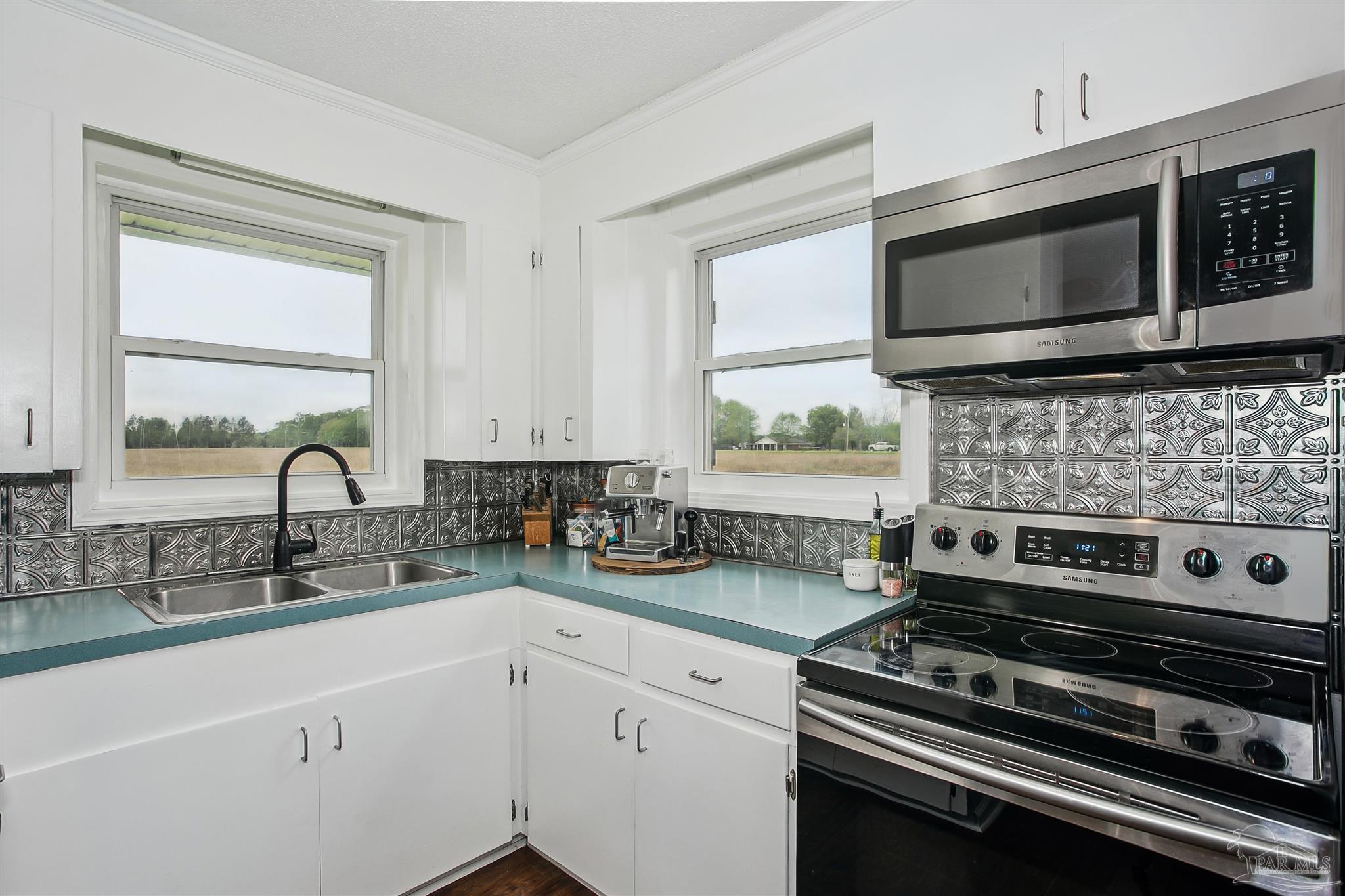 4075 Macks Road Century, FL 32535 - Photo 15 of 35 a kitchen with stainless steel appliances a stove microwave and sink