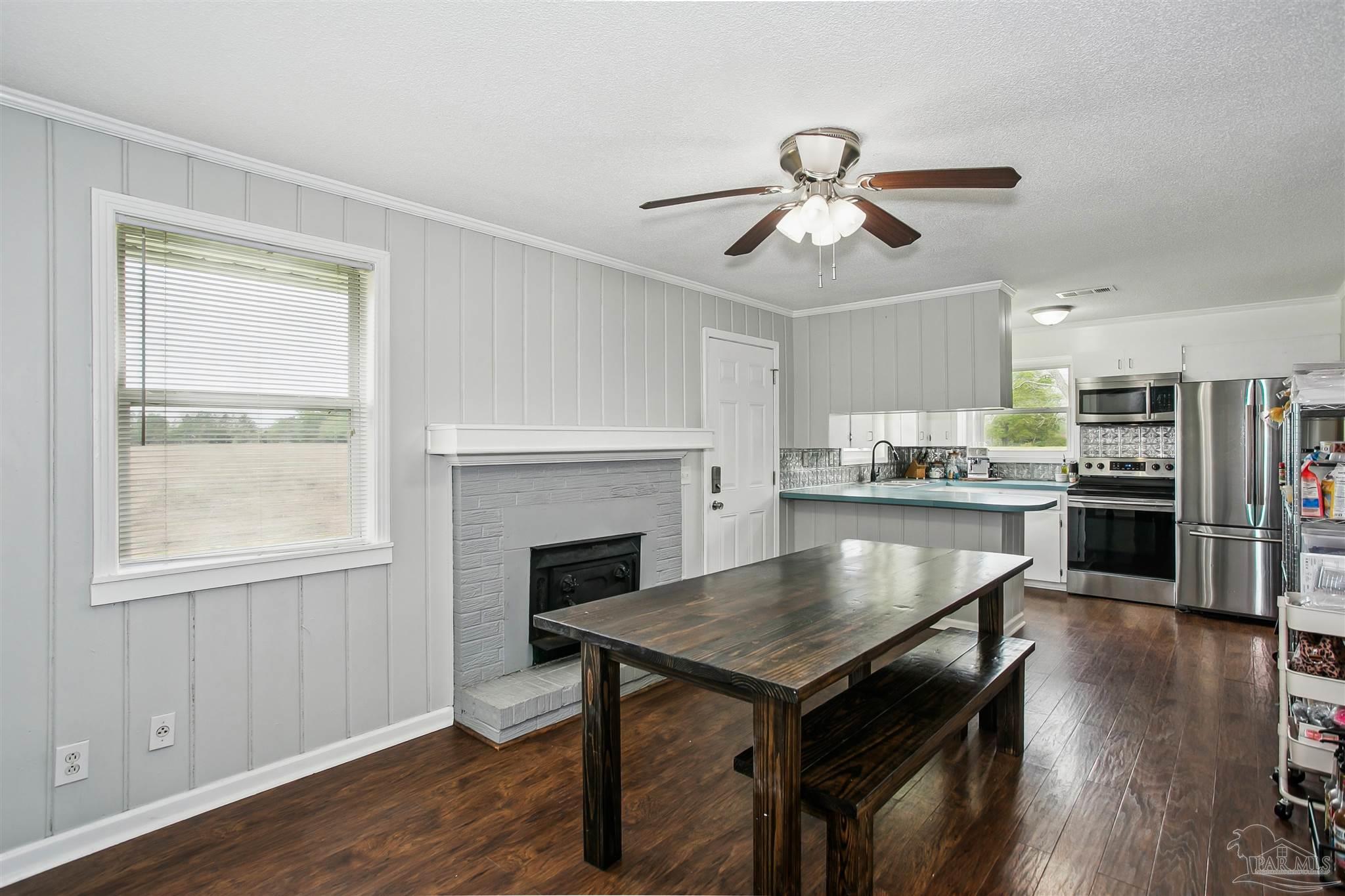 4075 Macks Road Century, FL 32535 - Photo 10 of 35 a kitchen with kitchen island a wooden floor and a refrigerator