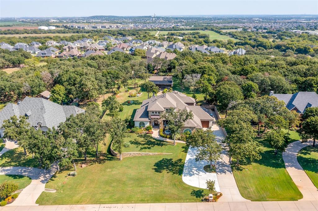 an aerial view of residential houses with outdoor space and trees