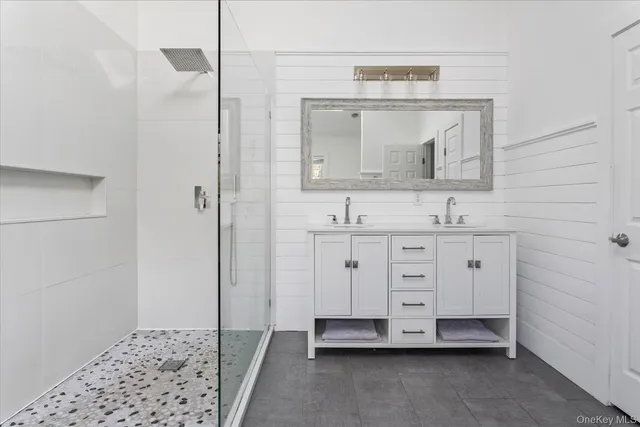 a bathroom with a sink a mirror and a shower