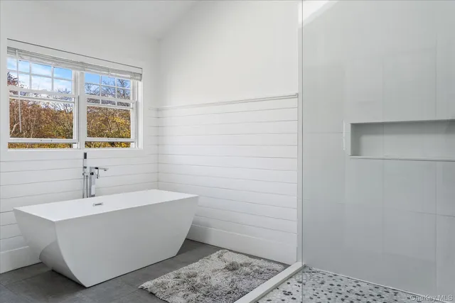 a bathroom with a white tub and shower