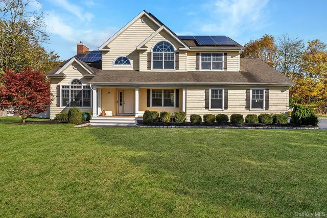 a front view of a house with a yard and trees