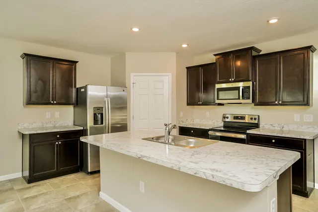 a kitchen with stainless steel appliances granite countertop a sink stove and refrigerator