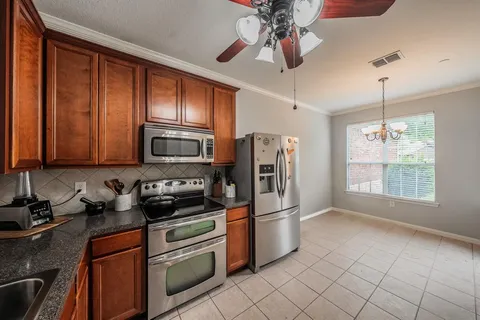 a kitchen with stainless steel appliances granite countertop a refrigerator a stove a sink and dishwasher