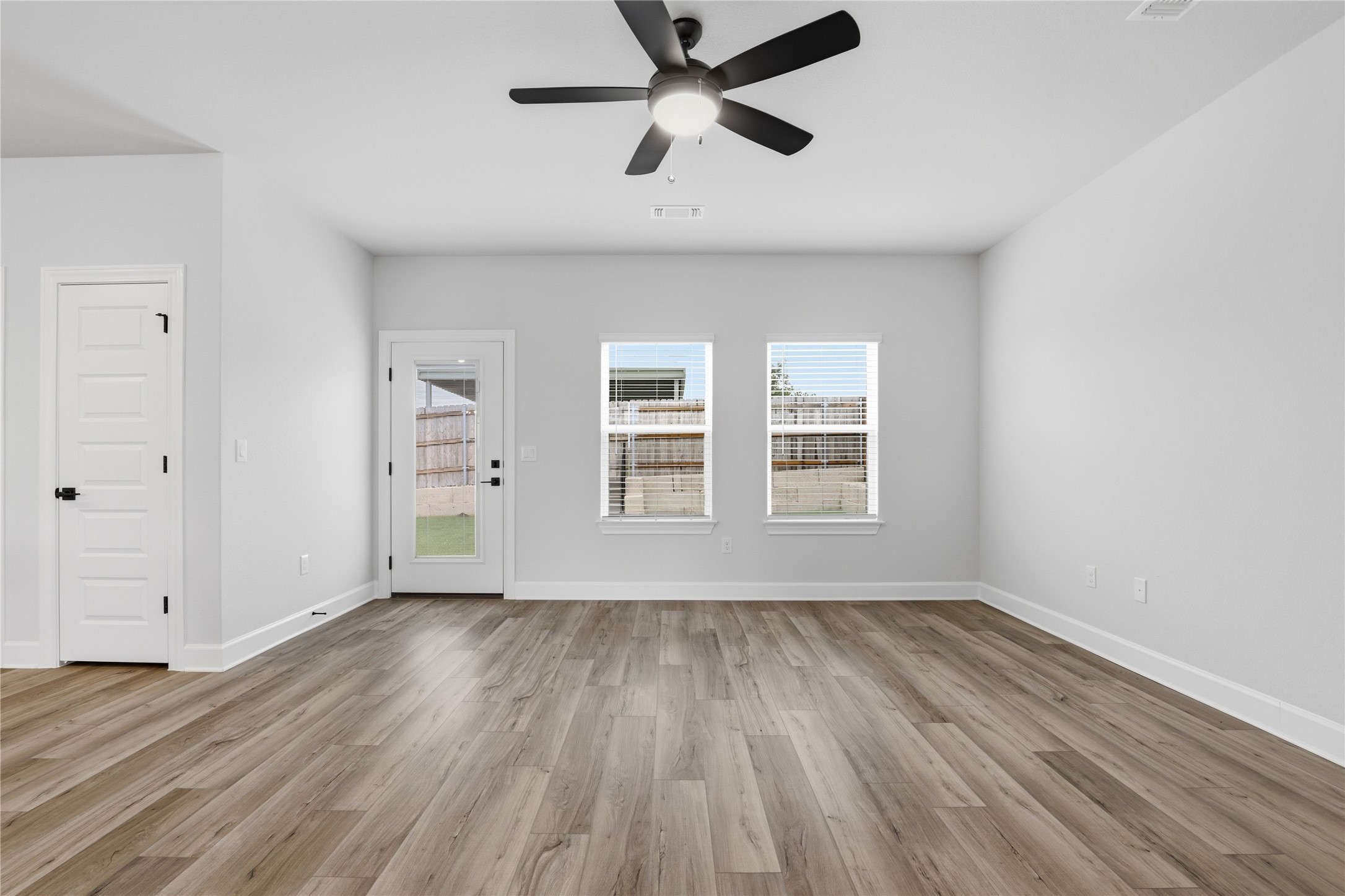 9320 Gladsome Path Manor, TX 78653 - Photo 10 of 34 a view of an empty room with wooden floor and a window