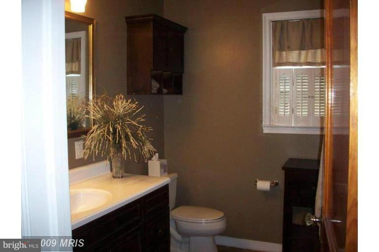 4313 Chapel Road Perry Hall, MD 21128 - Photo 5 of 23 a bathroom with a granite countertop sink toilet and mirror