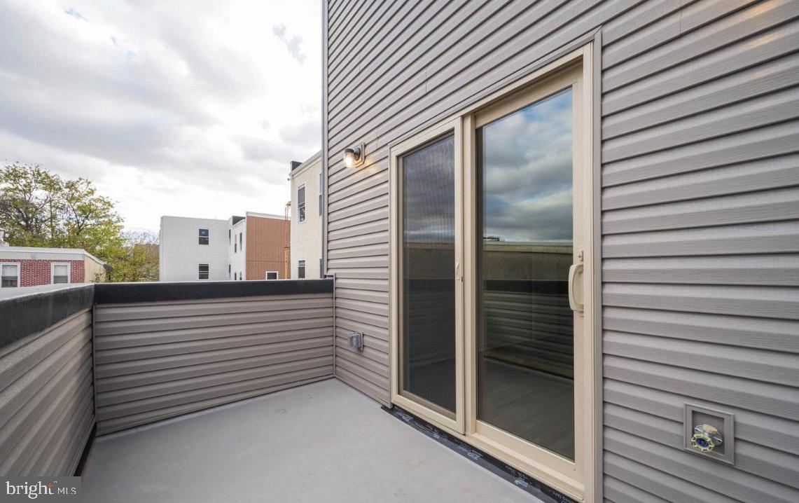 a view of a balcony with refrigerator and wooden fence