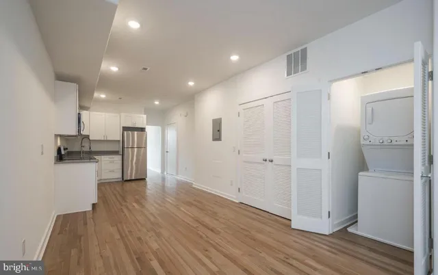 a kitchen with stainless steel appliances granite countertop a stove top oven a sink dishwasher and a microwave oven with wooden floor