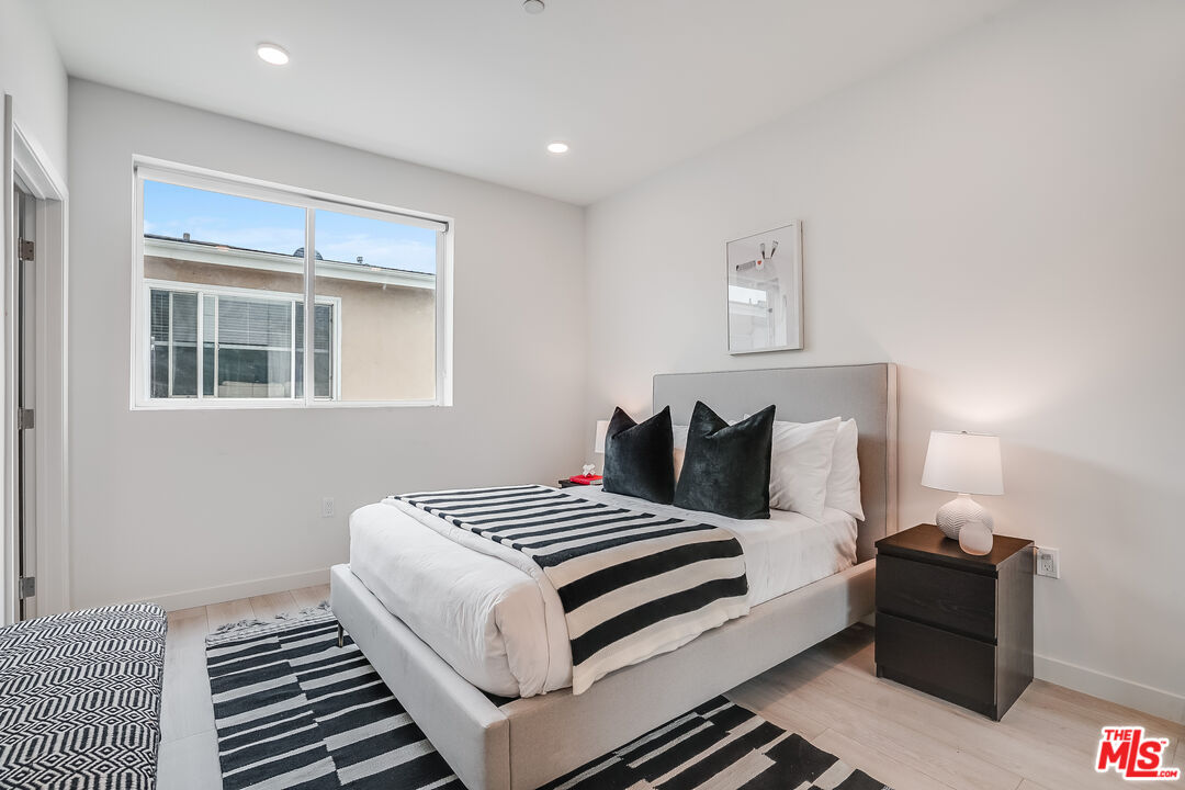 1021 South Shenandoah Street, Unit 501 Los Angeles, CA 90035 - Photo 14 of 19 a bedroom with a bed and wooden floor