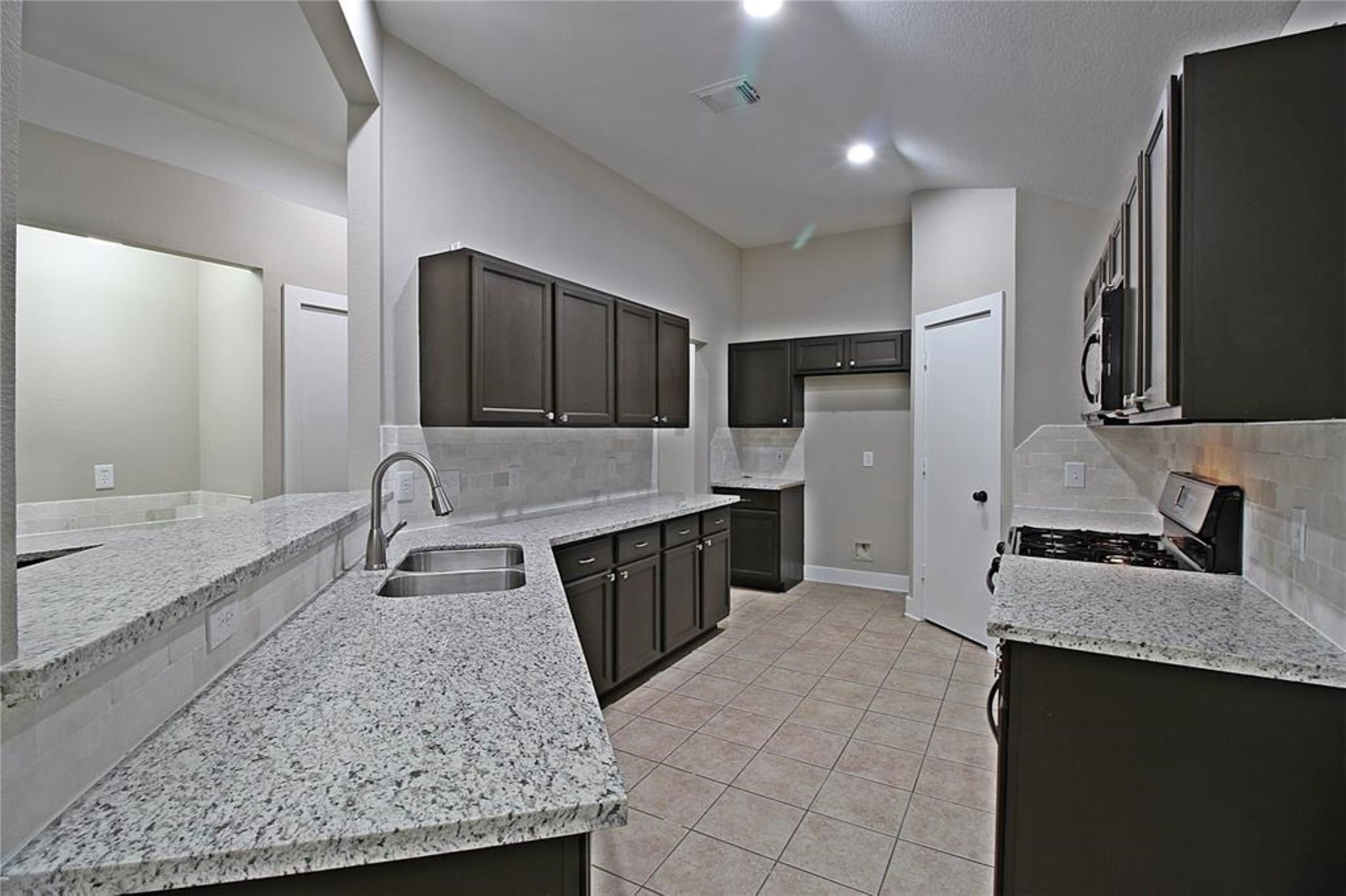 20022 Rustic Lake Lane Cypress, TX 77433 - Photo 3 of 16 a large kitchen with a stove a sink and a microwave