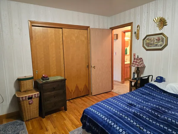 a bedroom with a bed and wooden floor