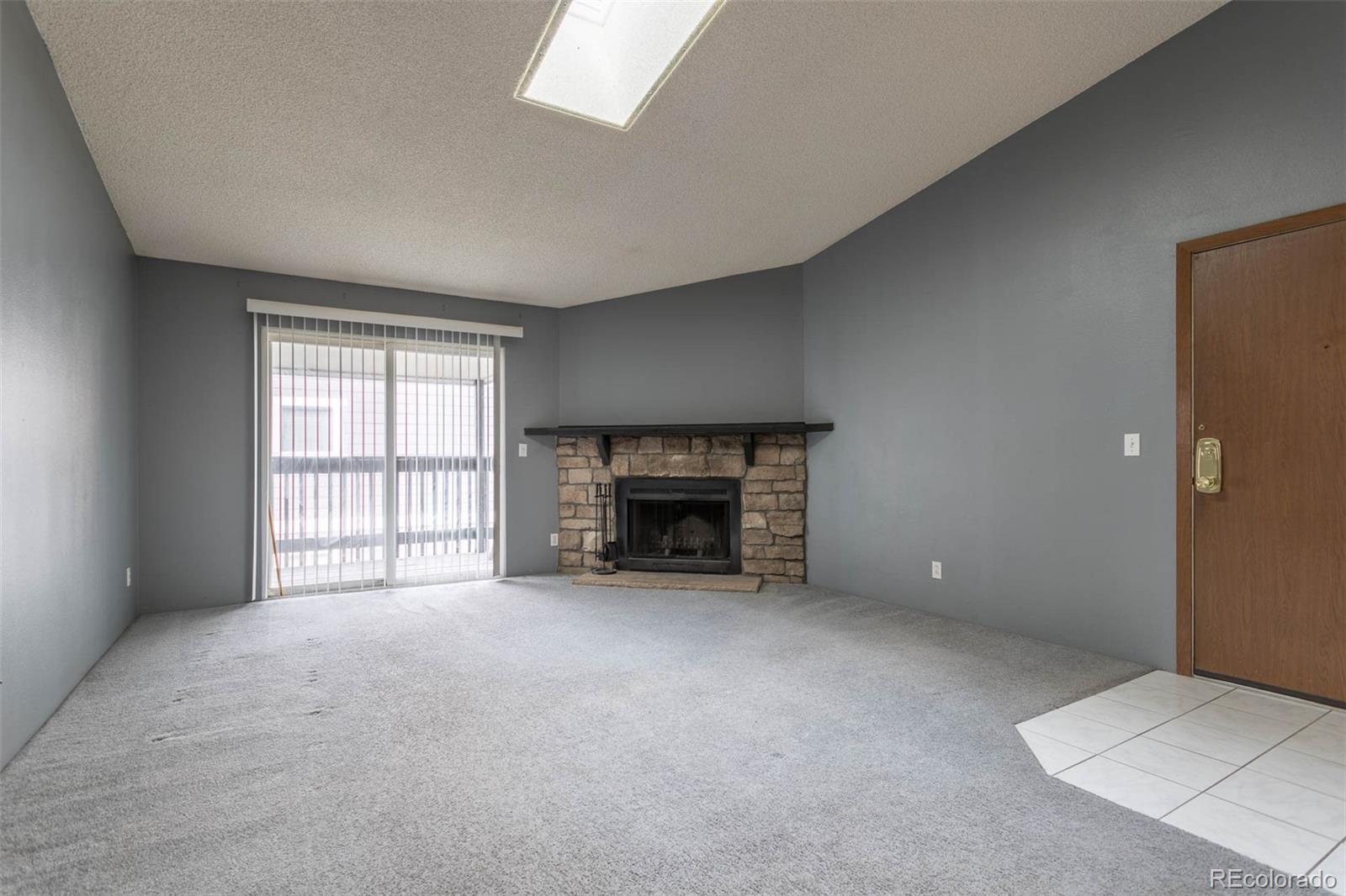 3462 South Eagle Street, Unit 201 Aurora, CO 80014 - Photo 2 of 26 an empty room with a fireplace and window