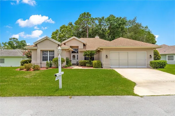 a front view of a house with a garden and yard