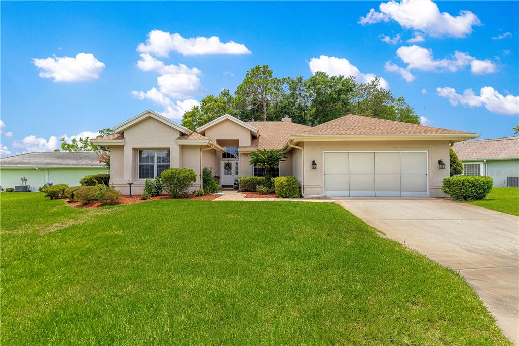 8418 Southwest 108th Pl Road Ocala, FL 34481 - Photo 50 of 80 a front view of a house with a yard and garage
