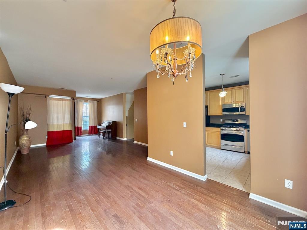 200 Dey Street, Unit 257 Harrison, NJ 07029 - Photo 4 of 21 a view of a livingroom with furniture wooden floor kitchen chandelier and a refrigerator