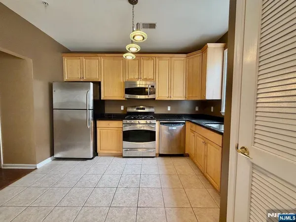 a kitchen with a refrigerator a stove a microwave and cabinets