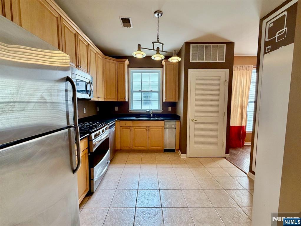 200 Dey Street, Unit 257 Harrison, NJ 07029 - Photo 6 of 21 a kitchen that has a kitchen island wooden cabinets and a stove
