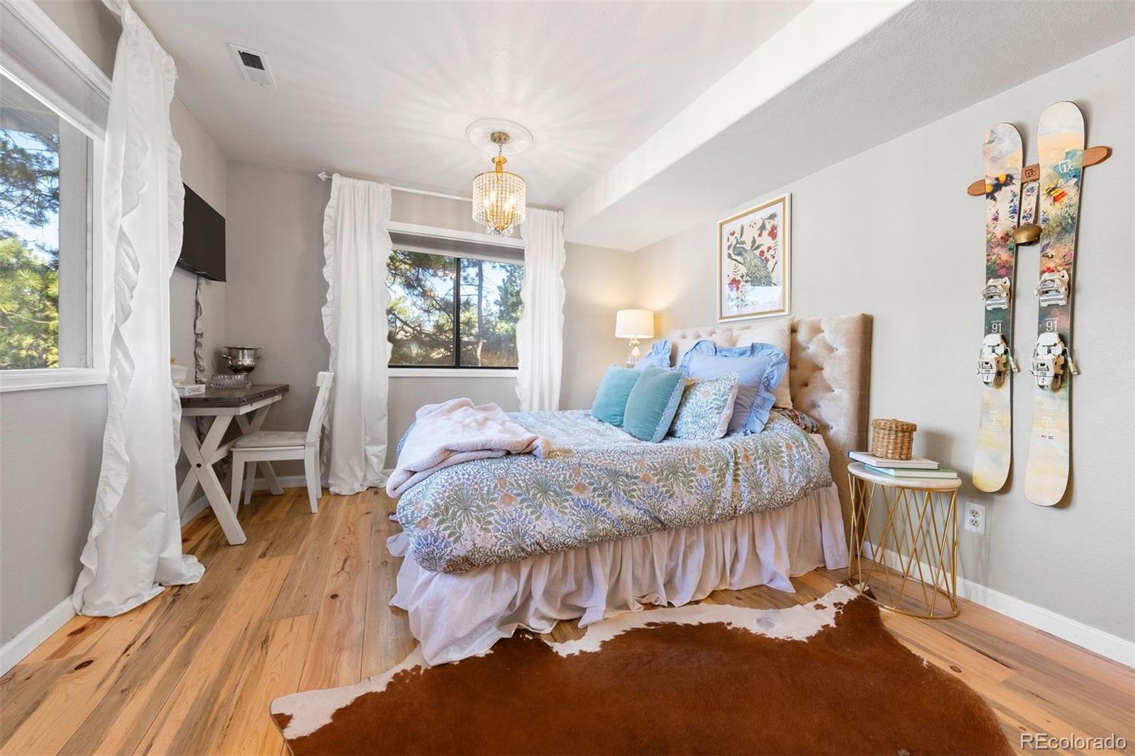 29895 Spruce Road Evergreen, CO 80439 - Photo 27 of 38 a spacious bedroom with a bed and a table in it