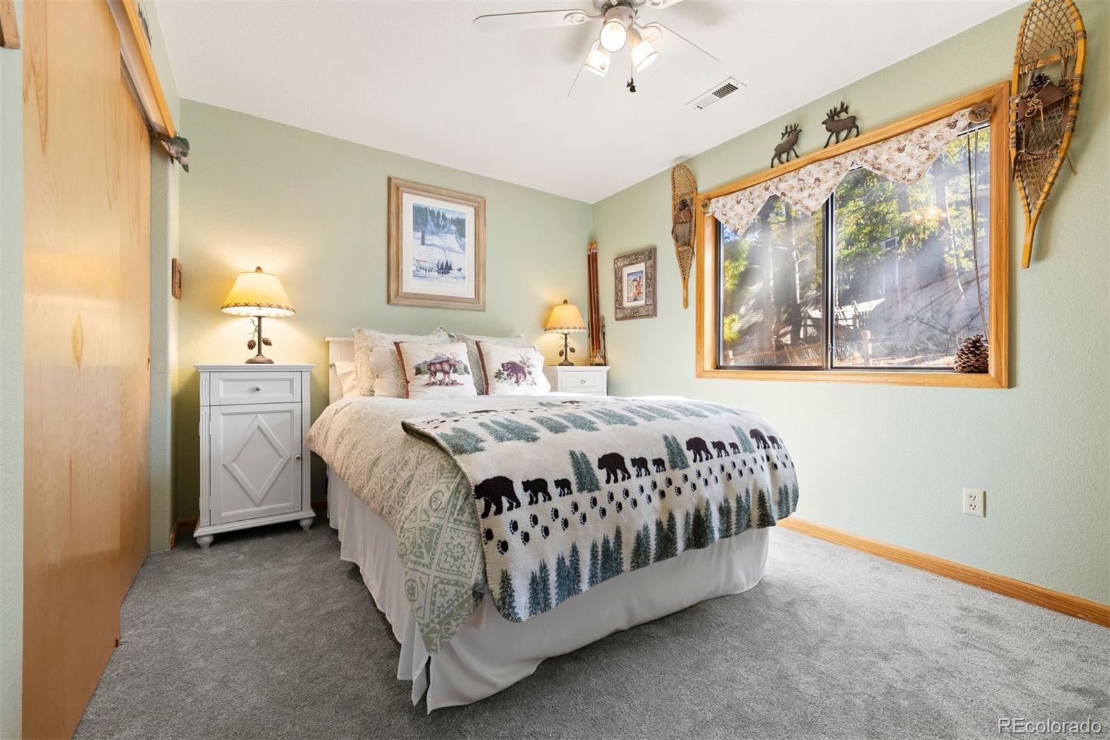 29895 Spruce Road Evergreen, CO 80439 - Photo 28 of 38 a spacious bedroom with a bed and a painting on the wall