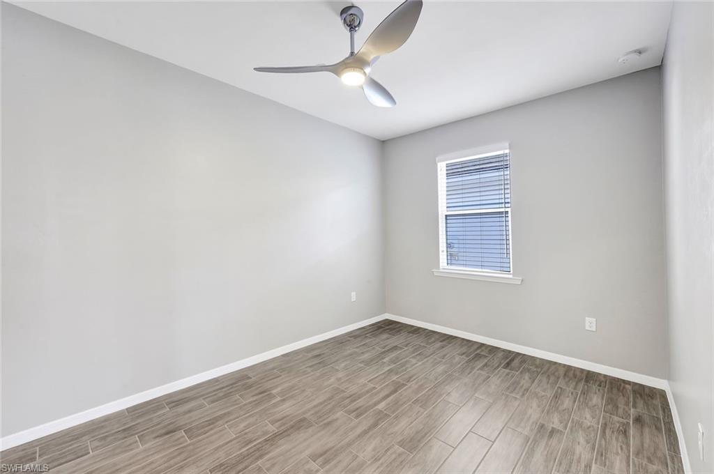 1261 Enbrook Loop Naples, FL 34114 - Photo 14 of 23 wooden floor in an empty room with a window