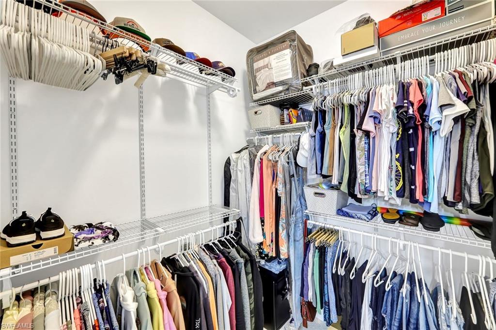 1261 Enbrook Loop Naples, FL 34114 - Photo 21 of 23 a view of walk in closet with clothes and shoes
