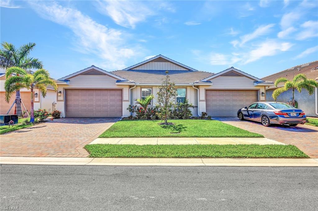 1261 Enbrook Loop Naples, FL 34114 - Photo 22 of 23 a front view of a house with a garden and trees