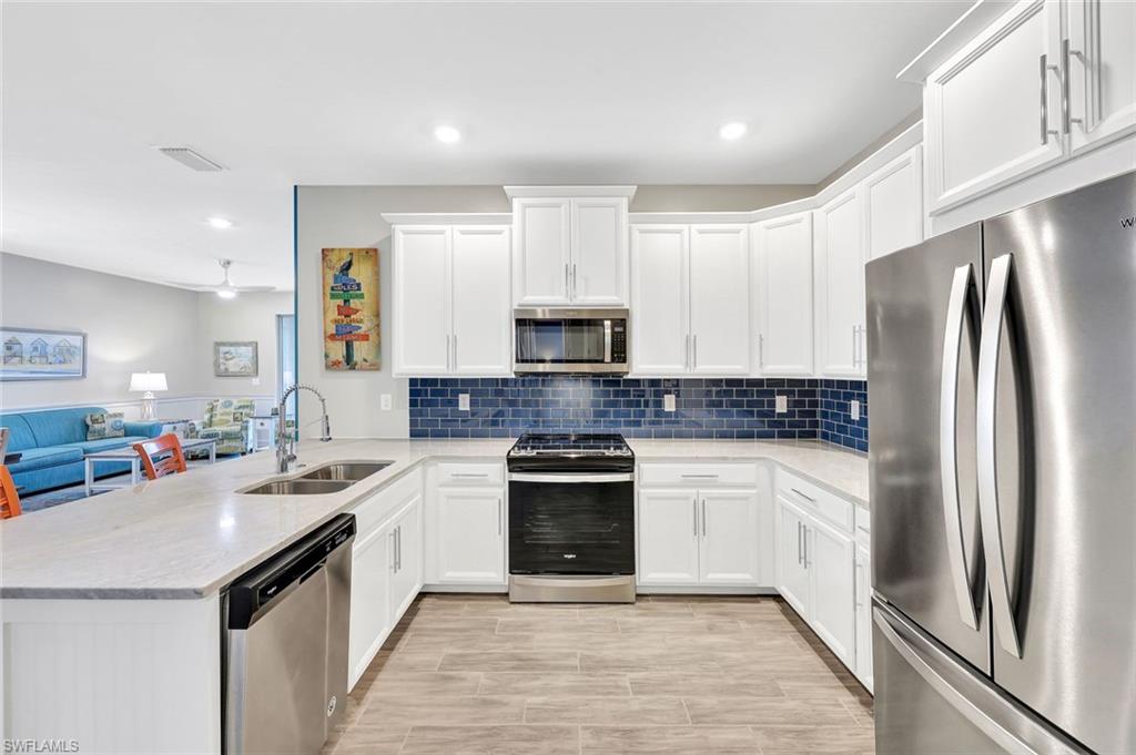 1261 Enbrook Loop Naples, FL 34114 - Photo 5 of 23 a kitchen with a sink stainless steel appliances and cabinets