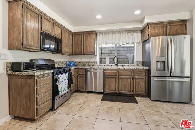 a kitchen with a sink counter top space appliances and cabinets