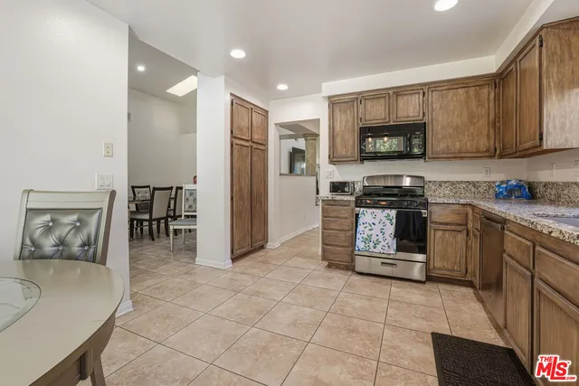 a kitchen with stainless steel appliances granite countertop a refrigerator and a stove top oven