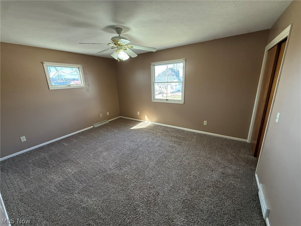 604 Harger Street Dover, OH 44622 - Photo 12 of 25 Empty room featuring ceiling fan, carpet flooring, and a textured ceiling