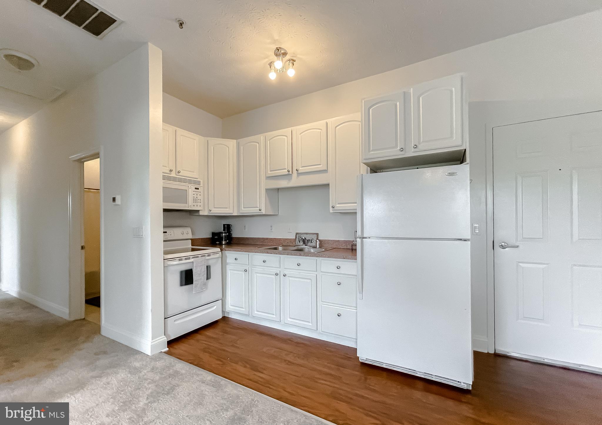 48673 Trapp Road St. Inigoes, MD 20684 - Photo 11 of 39 a kitchen with cabinets stainless steel appliances and wooden floor