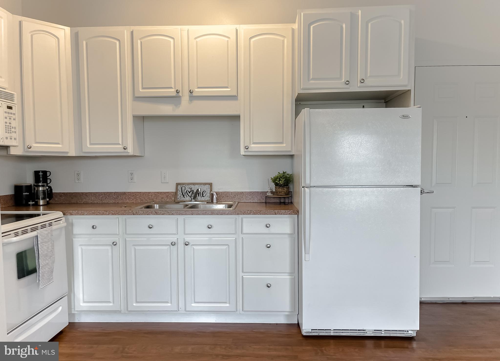 48673 Trapp Road St. Inigoes, MD 20684 - Photo 9 of 39 a kitchen with granite countertop white cabinets and refrigerator